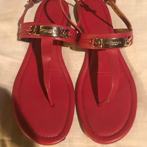 Coach red thong sandals with gold trimming.